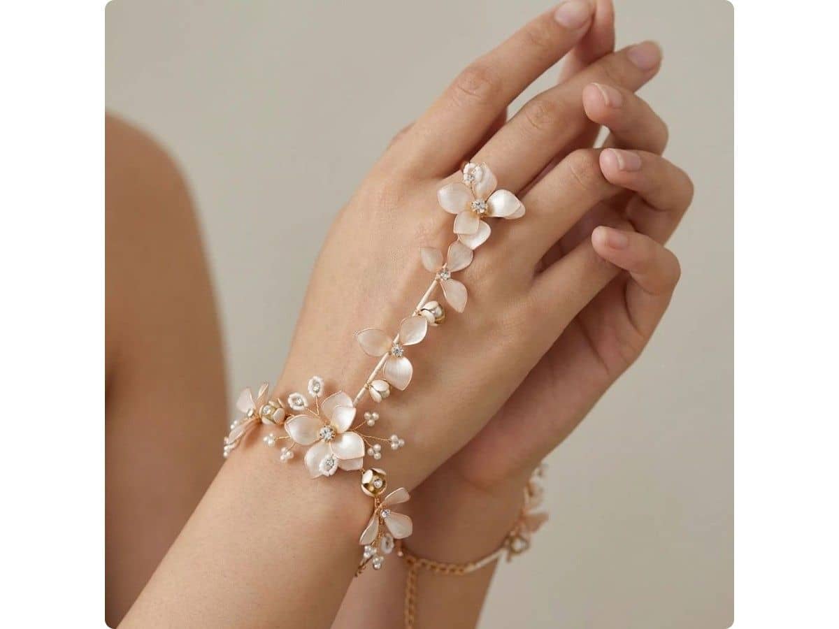 Blush resin flowers draped across the back of the hand from a bracelet to a ring