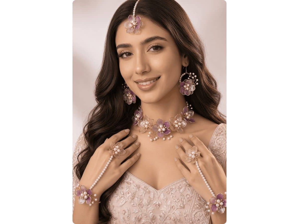 Light purple and transparent acrylic flowers with white pearls on a choker, with hoop earrings, maang tikka and pearl-chain haathphool on both hands