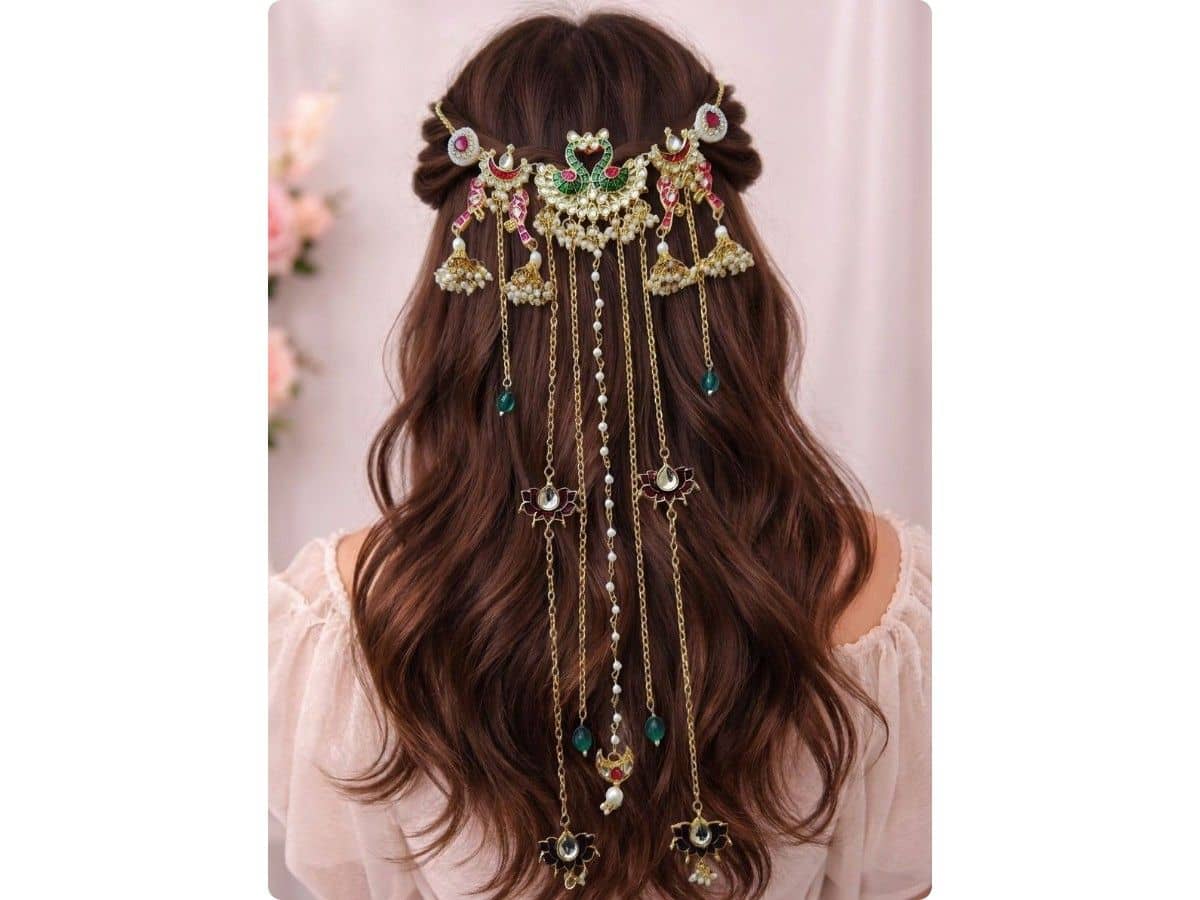 Peacock design in green and pink kundan-style stones with golden chains, pearls and jhumka charms across open hair